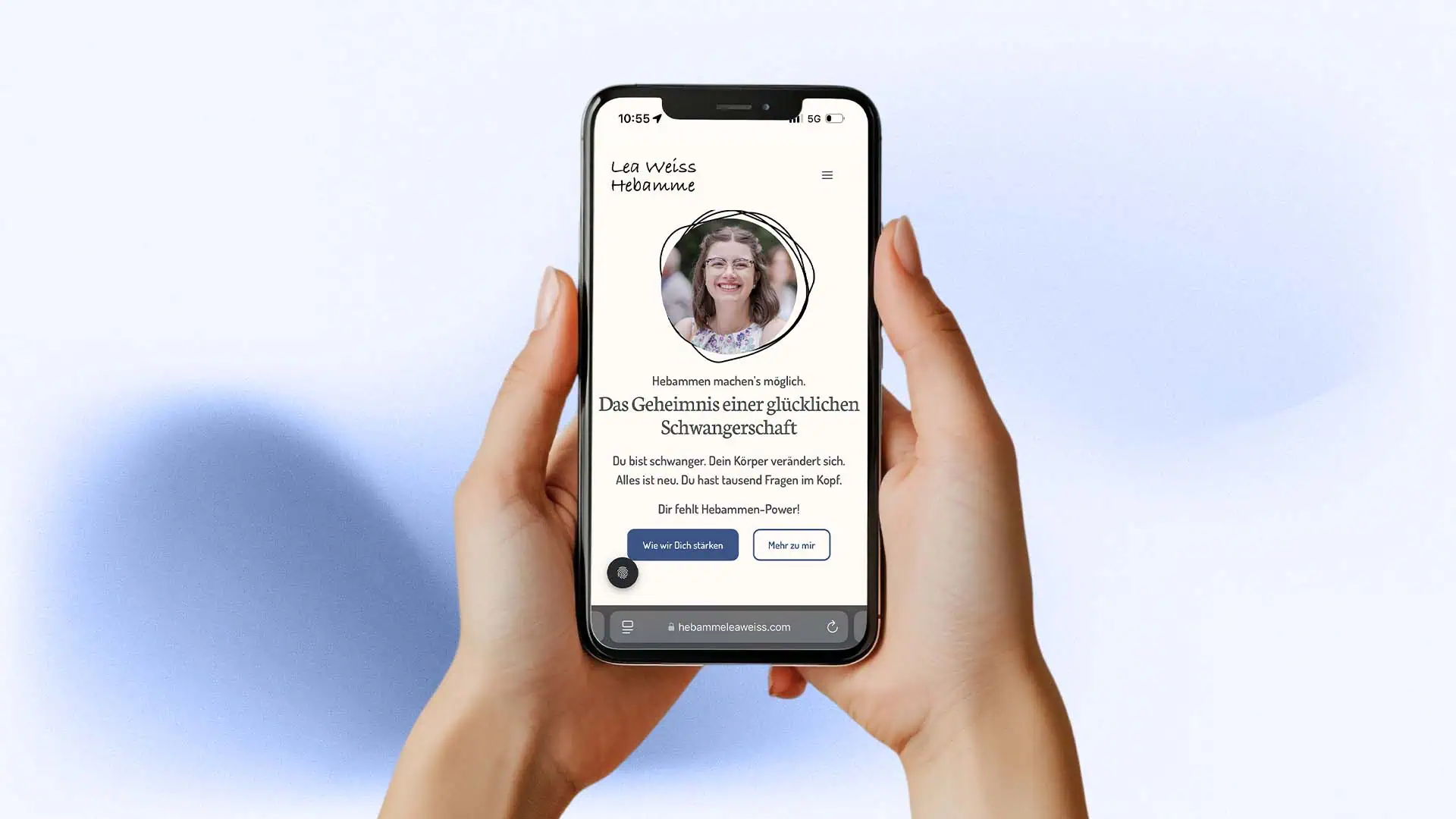 Zwei Hände halten ein Smartphone, auf dem die mobile Website von Lea Weiss Hebamme mit Portraitfoto und dem Text Das Geheimnis einer glücklichen Schwangerschaft zu sehen ist.